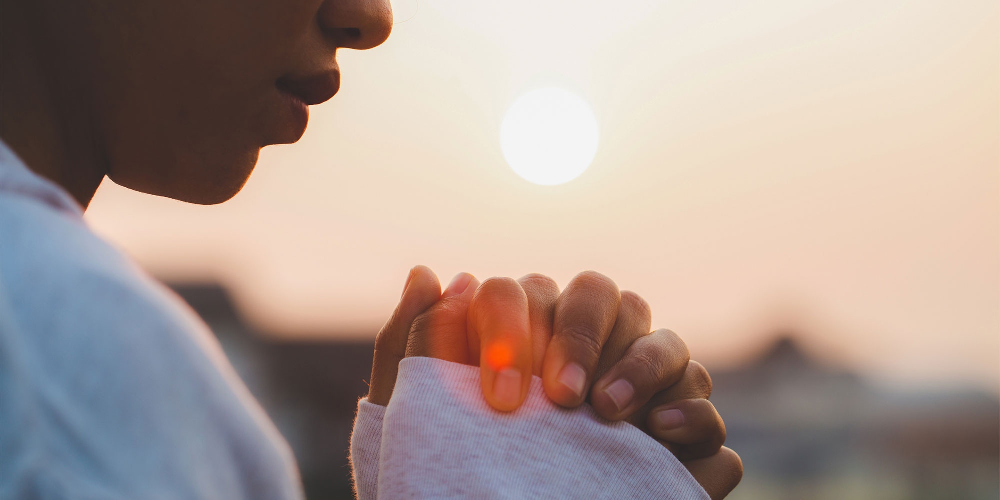 Woman praying outside at dusk